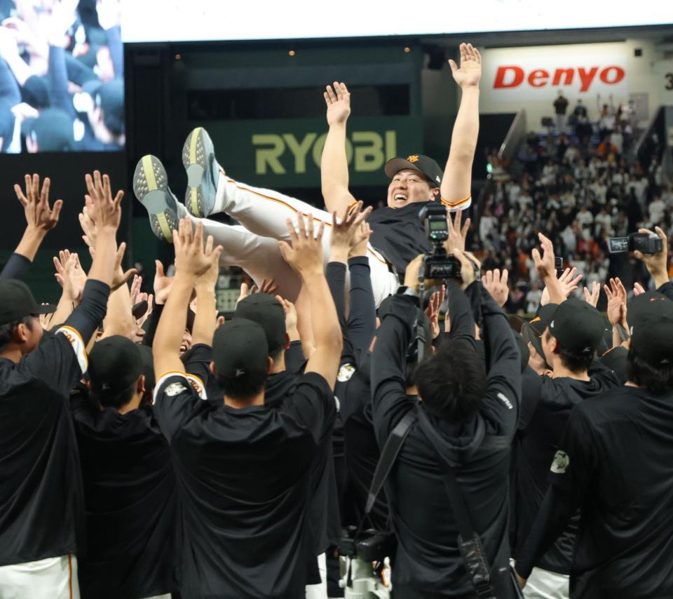 　ナインに胴上げされ、笑みを浮かべる岡本（撮影・西岡正）