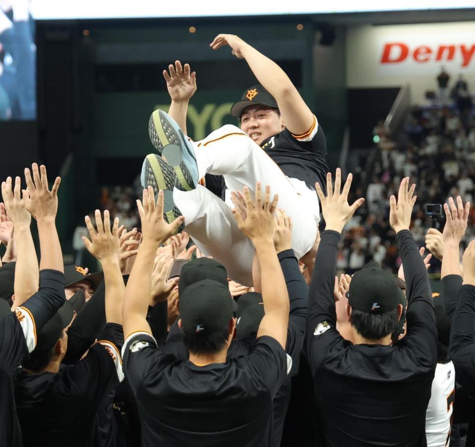 　ナインに胴上げされ、笑みを浮かべる岡本（撮影・西岡正）