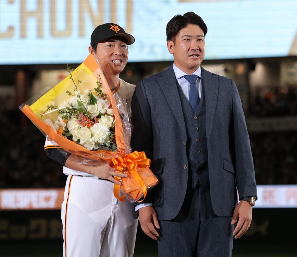 　菅野（右）から花束を受け取った長野久義氏（撮影・西岡正）
