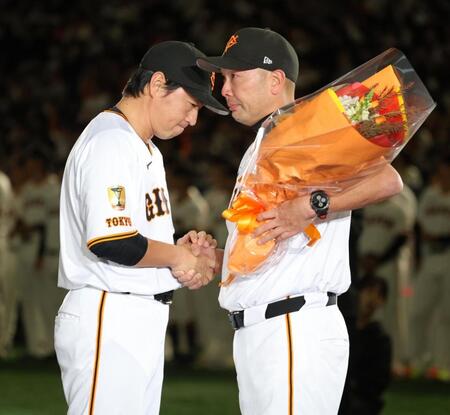 　阿部監督（右）から花束を受け取り、かたく握手する長野久義氏（撮影・西岡正）