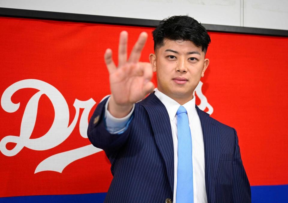 　契約を更改し、ポーズをとる松山