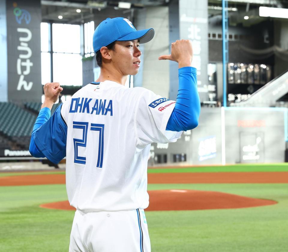 　マウンドを背に背番号２７を指さす大川慈英（撮影・中島達哉）