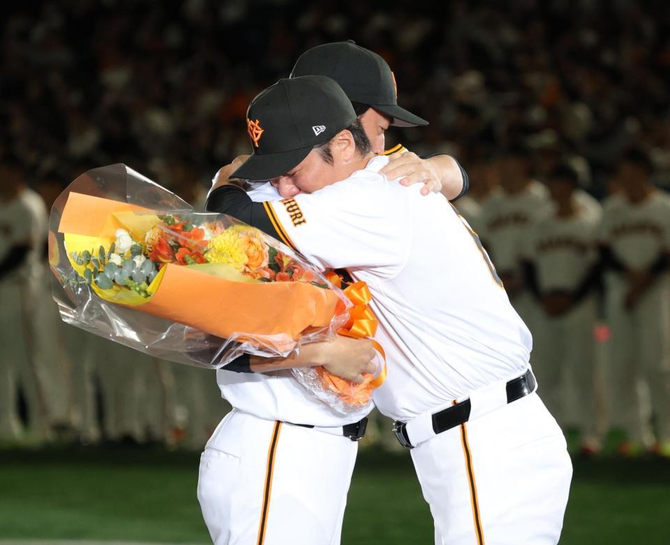 　花束を渡した坂本勇人（手前）と抱擁する長野久義＝２３日