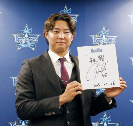 　契約更改交渉を終え、記者会見で抱負を記した色紙を掲げるＤｅＮＡの森原＝２６日、横浜市の球団事務所