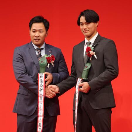 　最優秀新人賞を受賞し、握手する荘司（左）と西川（撮影・西岡正）