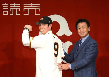 　背番号「９」を披露する松本。右は水野編成本部長（撮影・堀内翔）