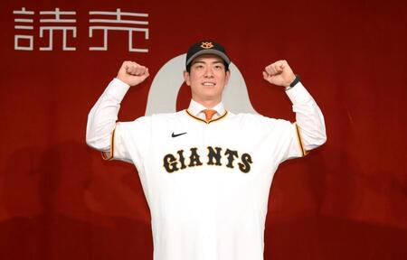 　ユニホームに袖を通してポーズを決める松本（撮影・堀内翔）