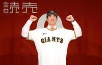 　ユニホームに袖を通してポーズを決める松本（撮影・堀内翔）