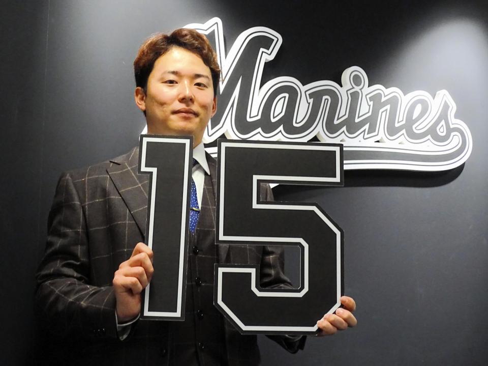 　横山が２０００万円増で契約更改。来季から背負う背番号「１５」のボードを手に笑顔