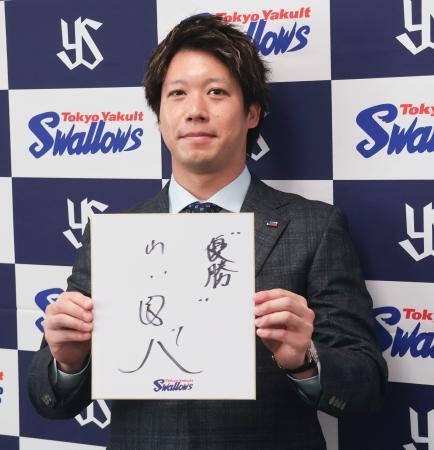 　契約更改交渉を終え、記者会見で来季の抱負を記した色紙を掲げるヤクルト・山田＝２８日、神宮球場
