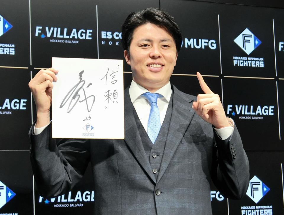 　来季年俸１億円で契約を更改し、笑顔でポーズをとる田中