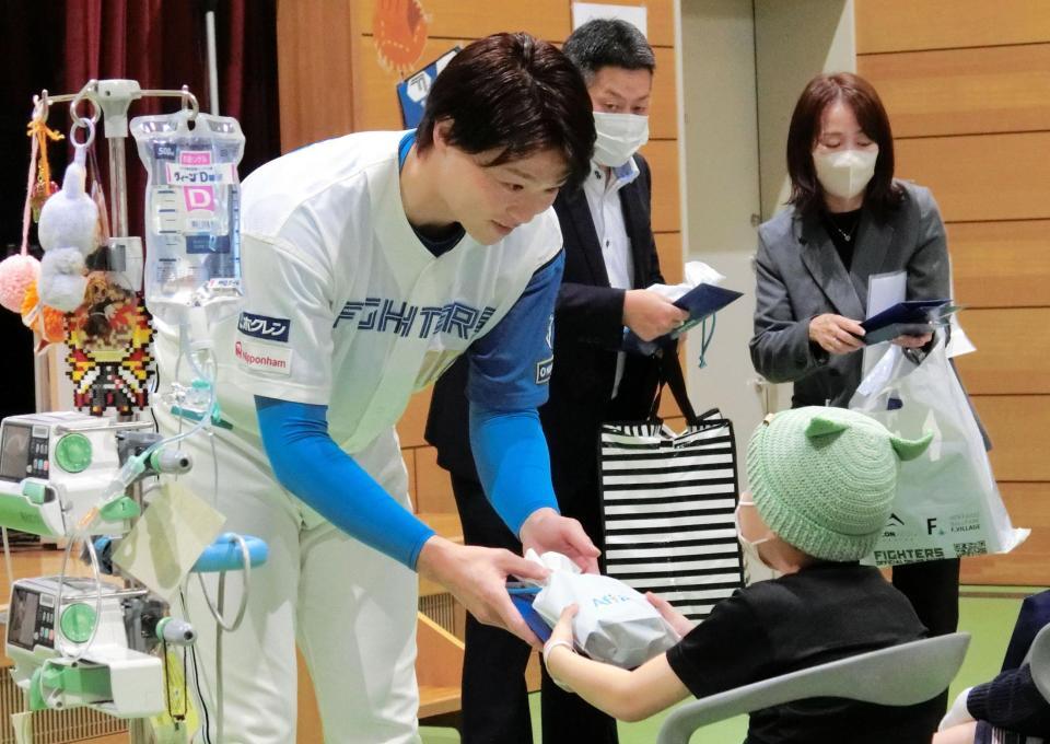 　入院中の子供にプレゼントを手渡す山崎