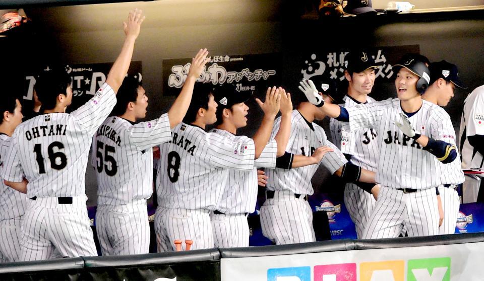 　坂本勇人（右）は左越えにソロを放ち、大谷翔平（背番号１６）らナインとタッチを交わす＝２０１５年１１月