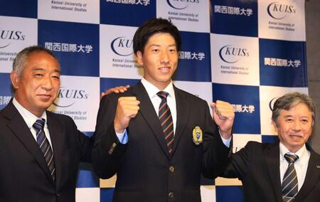 巨人１位指名を受けて喜び合う関西国際大の翁田大勢（中央）と山下泰生部長（右）、鈴木英之監督＝２０２１年１０月