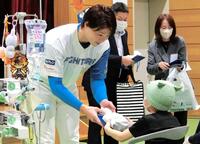 　入院中の子どもにプレゼントを手渡す山崎（撮影・藤田昌央）