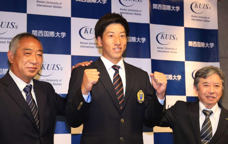 巨人１位指名を受けて喜び合う関西国際大の翁田大勢（中央）と山下泰生部長（右）、鈴木英之監督＝２０２１年１０月