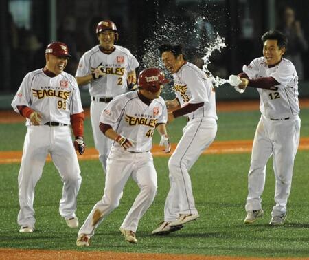 　鉄平（中央）がサヨナラ打を放ち、ナインから水を掛けられそうになるも、平石洋介（右から２人目）が身代わりになる（左は中村紀洋）=２０１０年６月