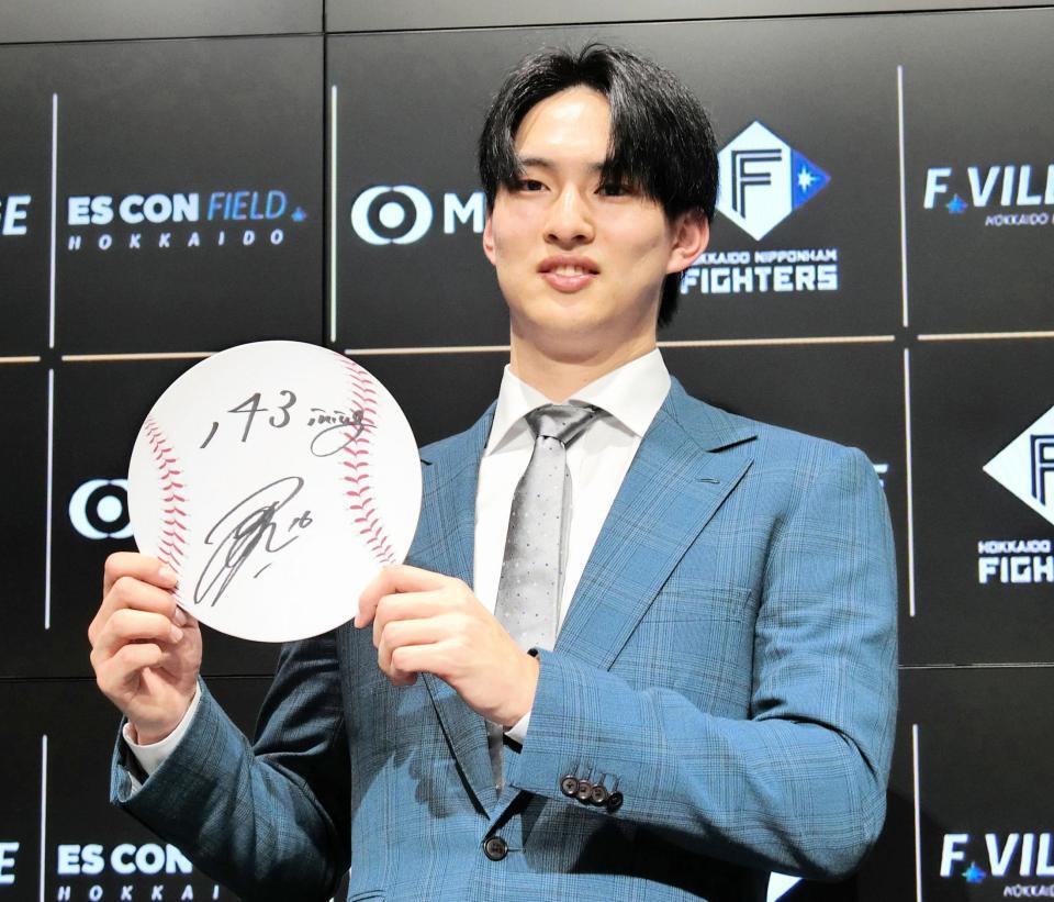 　契約を更改し、来季の目標「１４３イニング」を記したボードを掲げる達