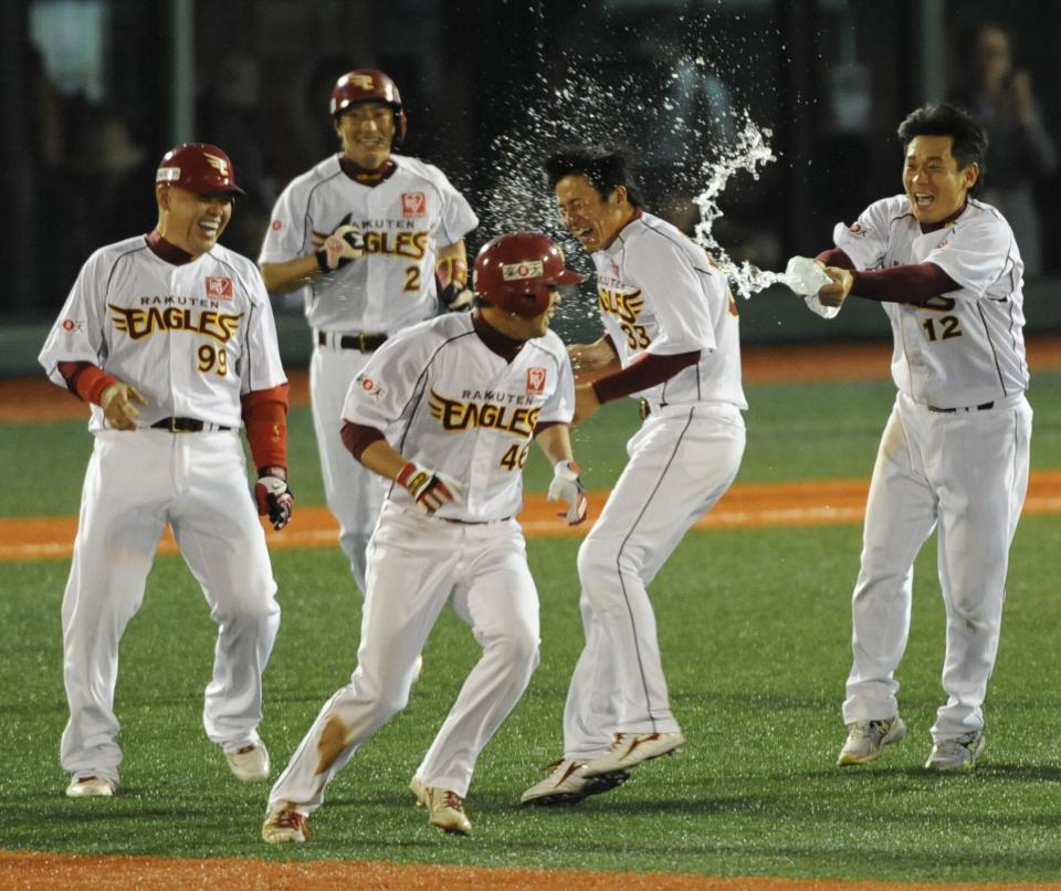 　鉄平（中央）がサヨナラ打を放ち、ナインから水を掛けられそうになるも、平石洋介（右から２人目）が身代わりになる（左は中村紀洋）=２０１０年６月