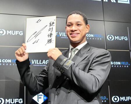 　契約を更改し、来季の目標を記した色紙を手に笑顔を見せる万波
