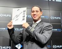 　契約を更改し、来季の目標を記した色紙を手に笑顔を見せる万波