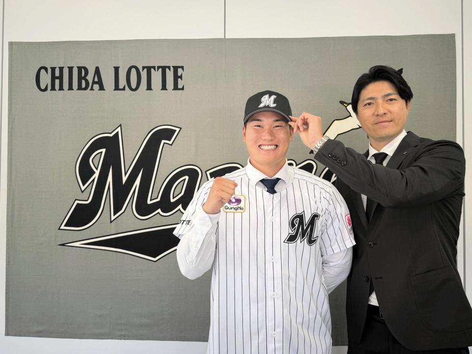 ロッテと仮契約したドラフト７位・田中（左）は担当の田中スカウトに帽子をかぶせてもらい笑顔（球団提供）