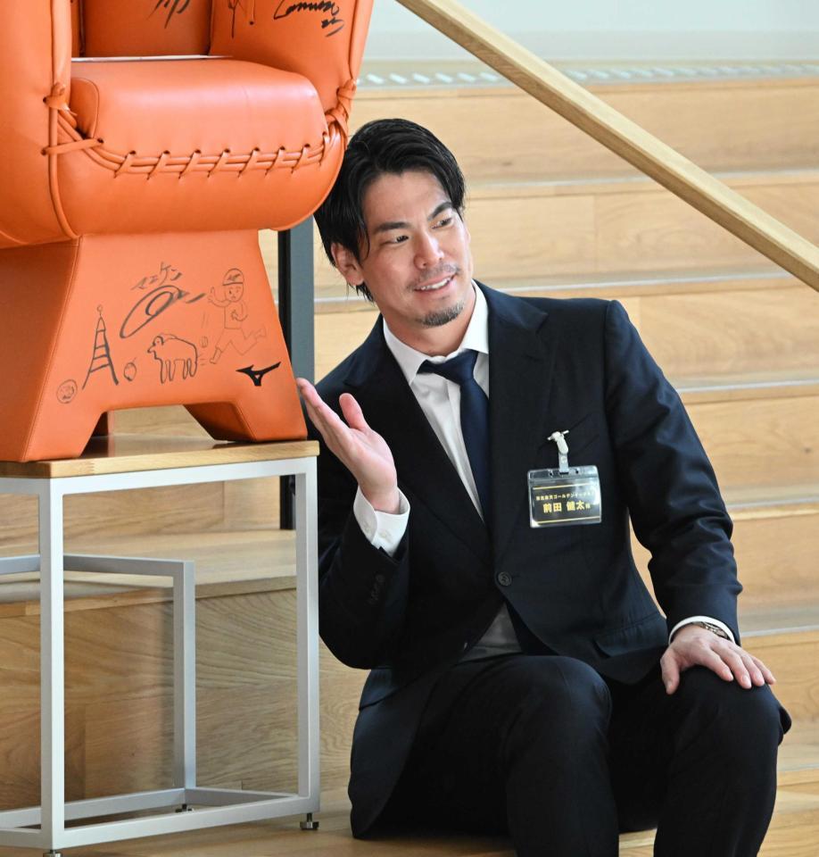 　ミズノブランドアンバサダーミーティングに参加し、イラストの前でポーズをとる前田