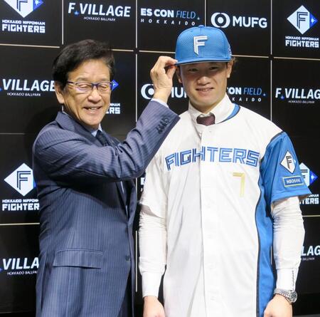 　入団記者会見を終え、撮影に応じる日本ハム・西川。左は栗山ＣＢＯ