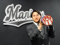 　大幅アップで契約更改。特大印鑑を担いで笑顔の西川