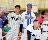 　三浦氏（奥）と子どものピッチングを見つめる伊原（撮影・中田匡峻）