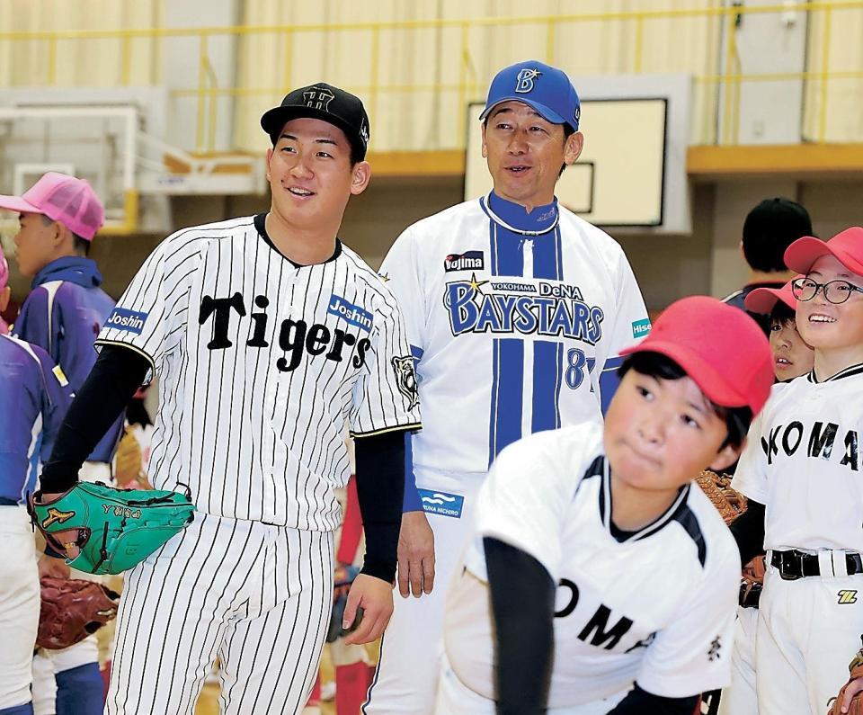 　三浦氏（奥）と子どものピッチングを見つめる伊原（撮影・中田匡峻）