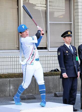 　鎌ケ谷警察署の一日署長を務め、出動式でスイングする梅林（左）