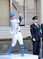 　鎌ケ谷警察署の一日署長を務め、出動式でスイングする梅林（左）