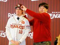 　楽天・前田健太（左）が入団会見。石井ＧＭに帽子をかぶせてもらう
