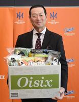 　就任記念で贈られた１８品のおためしセットを手に笑顔を見せる桑田ＣＢＯ（撮影・佐藤厚）