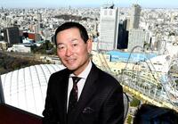 　４２階からの風景をバックに笑顔を見せる桑田ＣＢＯ（撮影・佐藤厚）