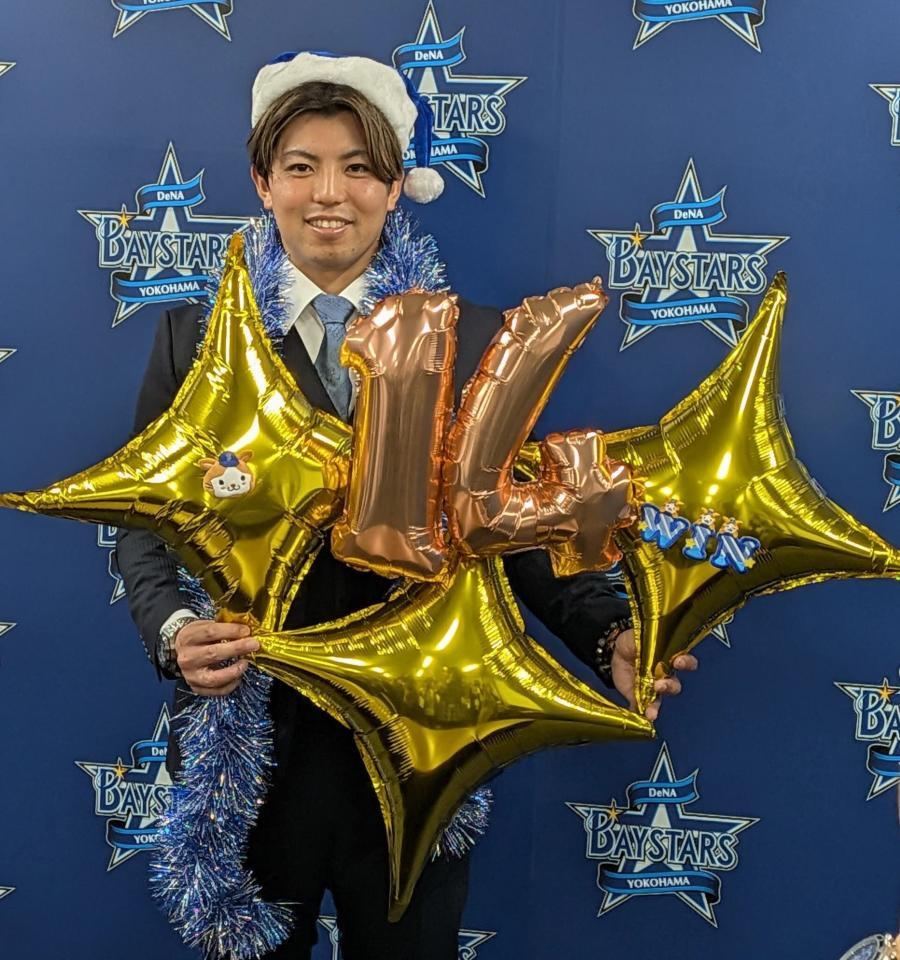 　クリスマスグッズを手に笑顔の東