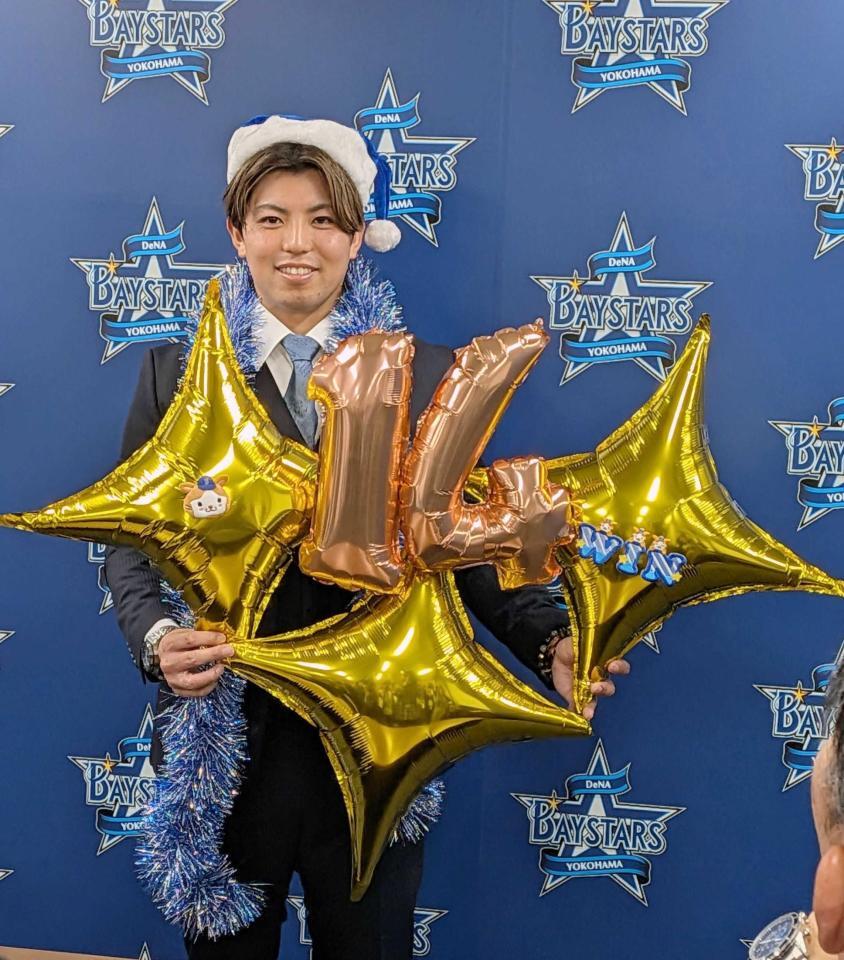 　クリスマスグッズを手に笑顔の東