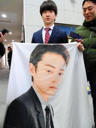 　菅田将暉の特大フラッグを報道陣に披露するロッテ育成３位の杉山（左）