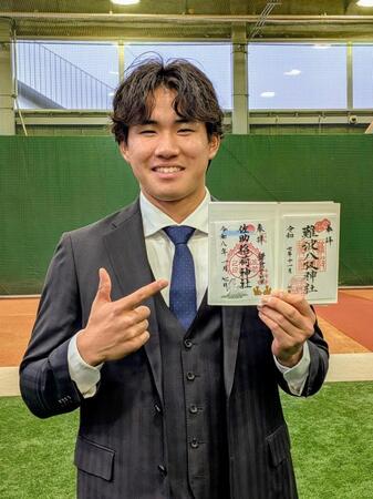 　御朱印帳を手に笑顔を見せる宮下