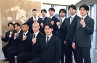 　長嶋茂雄氏の写真パネルの前で写真撮影する（前列右から）冨重、林、松井、河野、知念。（後列右から）竹丸、田和、山城、皆川、小濱、藤