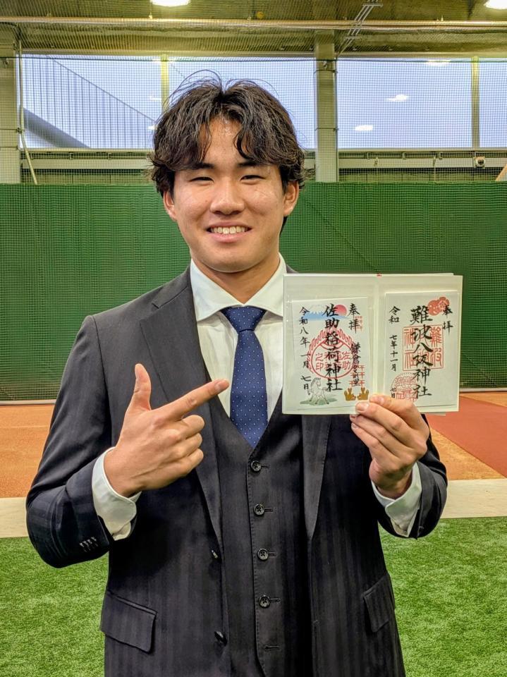 　御朱印帳を手に笑顔を見せる宮下