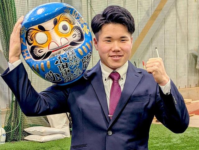 　青いダルマを手に決意をにじませる小田