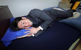 　持ち込んだ枕で寮のベッドに寝そべる竹丸