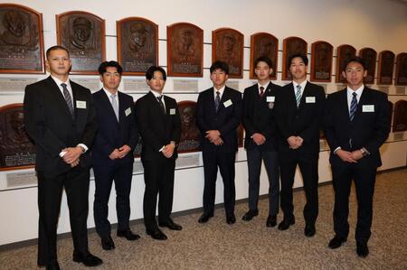吉田義男氏のレリーフの前で記念撮影する阪神のルーキーたち。（左から）能登、谷端、山崎、立石、早瀬、岡城、神宮（撮影・伊藤笙子）