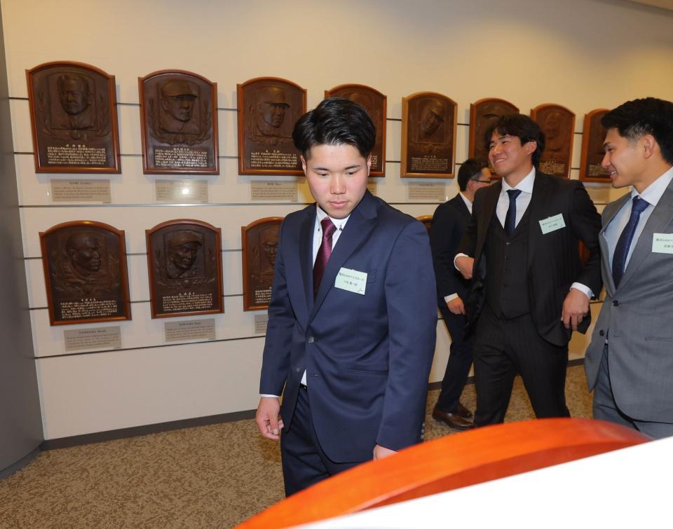 飾られているレリーフを見つめる小田康一郎（左）＝代表撮影）