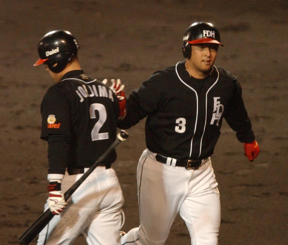 　松中(右)は中越えに追撃の一発を放ち城島とタッチ＝２００３年１０月