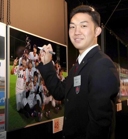 　展示されている自身の写真にサインを入れる石垣元（撮影・伊藤笙子）