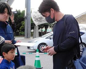 　ファンにサインをする前田健