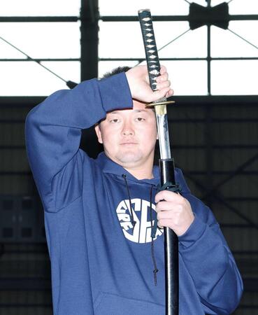 　練習で使用した居合練習刀を手にポーズを決める牧（撮影・西田忠信）